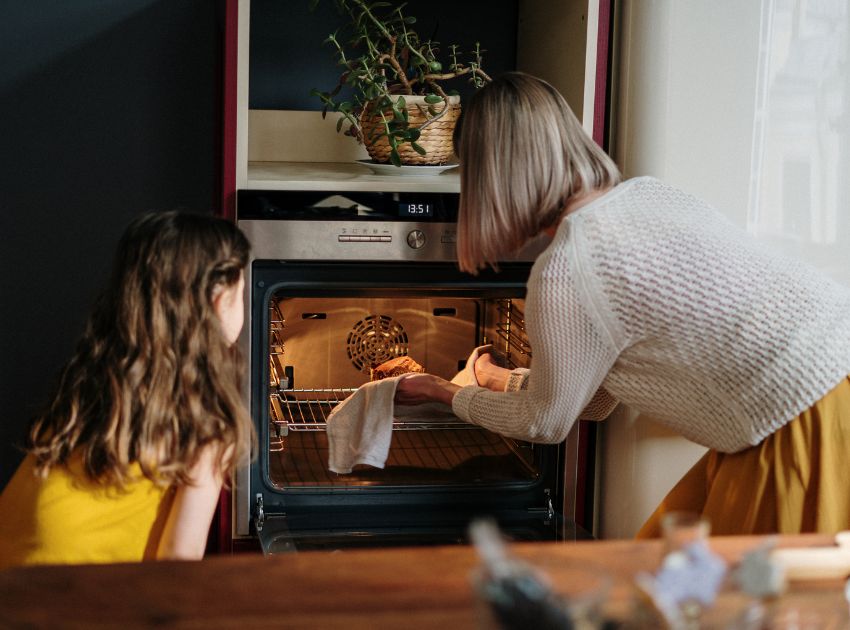 Kind und Oma schauen nach dem Kuchen im Ofen Kind und Oma schauen nach dem Kuchen im Ofen