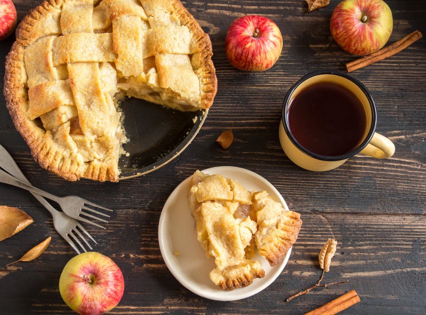 Gedeckter Apfelkuchen mit Gittermuster Gedeckter Apfelkuchen mit Gittermuster und eine Tasse Tee