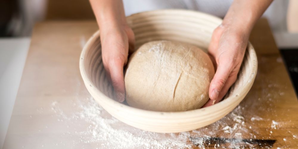 Teig wird in Gärkorb gelegt Teig wird in Gärkorb gelegt
