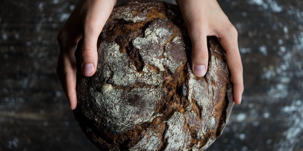 Zwei Hände halten ein frisches Brot Zwei Hände halten ein frisches Brot