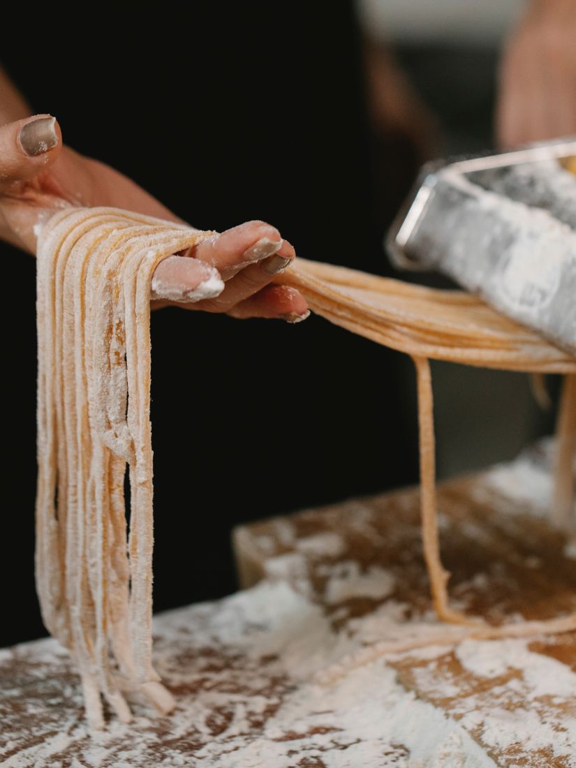 Pasta wird selber gemacht mit Nudelmaschine und den Händen