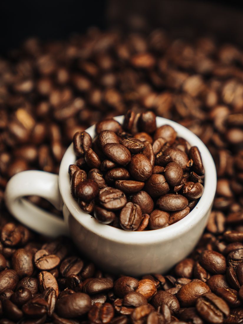 Espresso Tasse mit Kaffeebohnen in Inneren und drumherum