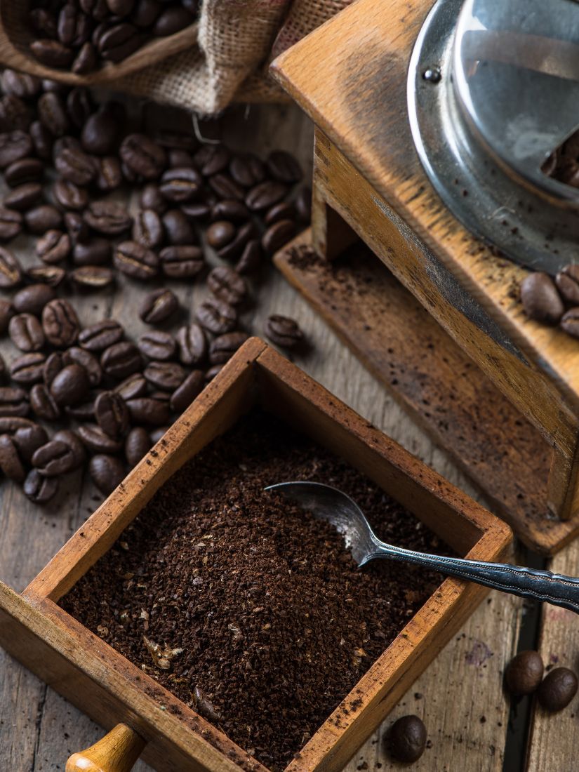 Kaffeemühle mit Frischgemahlenem Kaffee und Bohnen