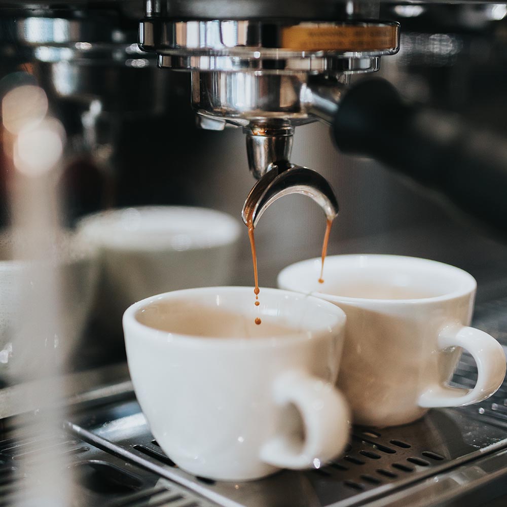 Frischer Espresso läuft aus dem Siebträger Frischer Espresso läuft aus dem Siebträger